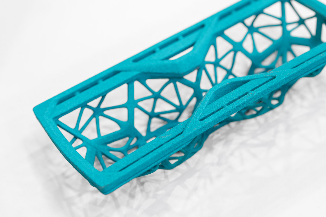 3d druck farbfinishing einer türkisfarbenen 3D-gedruckten Schlüsselhalterung für das Auto mit filigraner Gitterstruktur und matter Oberfläche