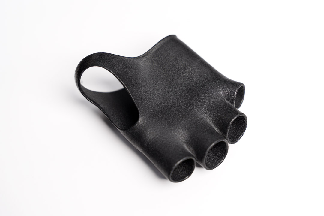 3d druck farbfinishing einer schwarzen Handorthese aus TPU, hergestellt im MJF Verfahren, mit ergonomischer Form und strukturierter Oberfläche auf weißem Hintergrund