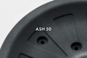 Close-up of a dark textured helmet surface with the label ASH 50 printed on it.