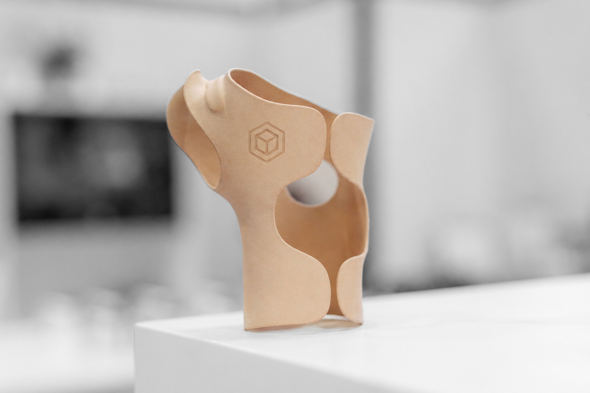 Hautfarbene 3D-gedruckte Orthese auf weißem Untergrund von einem Dienstleister für 3D-Druck-Orthesen.