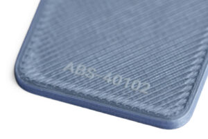 ABS 40102 - KIT3D GmbH – 3D-Technologie & Konstruktion Close-up of a textured blue plastic surface with an embossed code reading 046-4102 or similar.