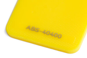 ABS 40400 - KIT3D GmbH – 3D-Technologie & Konstruktion Close-up of a bright yellow plastic corner with embossed code 'ABS-40400'.