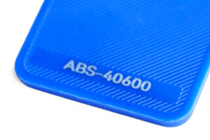 ABS 40600 - KIT3D GmbH – 3D-Technologie & Konstruktion Close-up of a blue plastic case corner with the embossed code ABS-40600 on a ridged surface.