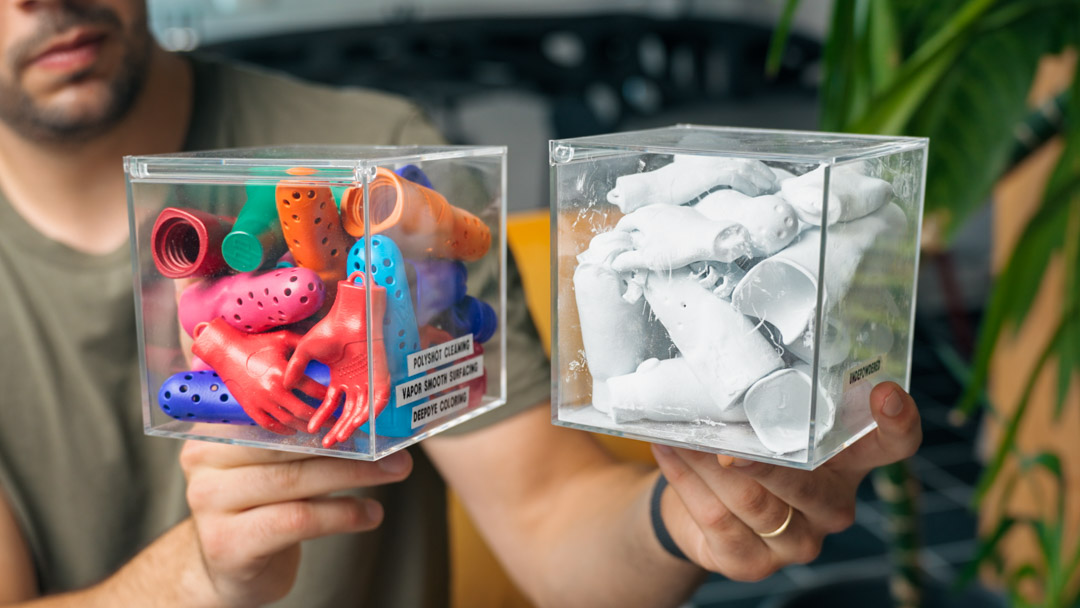 Vergleich von weißen, noch pulverbehafteten 3D-Druck-Bauteilen und farbig nachbearbeiteten Bauteilen nach automatischem Entpulvern und Oberflächenfinish.
