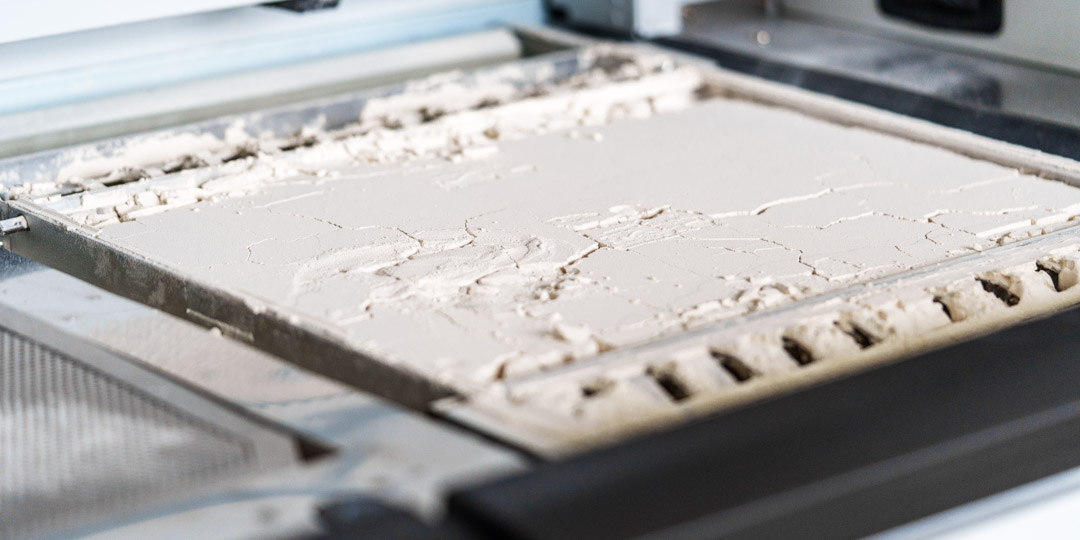 Bauteile im Pulverbett einer MJF-3D-Druckanlage während der additiven Fertigung