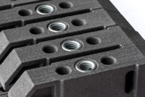 SLS-Bauteile aus PA12 mit mehreren eingesetzten Eindrehbuchsen