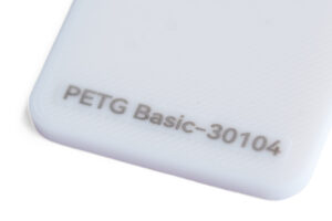 PETG Basic 30104 - KIT3D GmbH – 3D-Technologie & Konstruktion Close-up of a white plastic corner with embossed text 'PETG Basic-30104'.