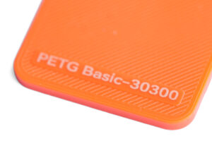 PETG Basic 30300 - KIT3D GmbH – 3D-Technologie & Konstruktion Close-up of an orange surface with the text 'PETG Basic-30300' near the edge.
