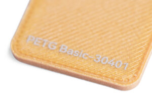PETG Basic 30401 - KIT3D GmbH – 3D-Technologie & Konstruktion Close-up of a tan textured 3D-printed card edge with the text 'PETG Basic-30401'