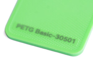 PETG Basic 30501 - KIT3D GmbH – 3D-Technologie & Konstruktion Close-up of a bright green plastic surface with a diagonal ridged texture and the label 'PETG Basic-30501'.
