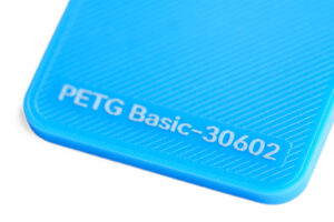 PETG Basic 30602 - KIT3D GmbH – 3D-Technologie & Konstruktion Close-up of a bright blue plastic item showing embossed text: 'PETG Basic-30602' at the corner.