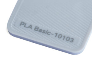 PLA Basic 10103 - KIT3D GmbH – 3D-Technologie & Konstruktion Close-up of light blue plastic with embossed text 'PLA Basic-10103' on a ribbed surface.