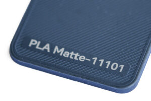 PLA Matte 11101 - KIT3D GmbH – 3D-Technologie & Konstruktion Close-up of a blue textured PLA surface labeled 'PLA Matte-11101'.