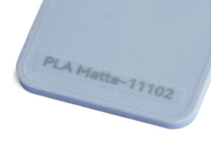 PLA Matte 11102 - KIT3D GmbH – 3D-Technologie & Konstruktion Close-up of a light blue textured surface with embossed text 'PLA Matte-1102'.)