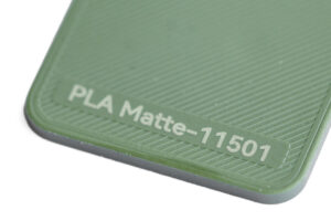 PLA Matte 11501 - KIT3D GmbH – 3D-Technologie & Konstruktion Close-up of a green textured surface with the embossed text 'PLA Matte-11501'.)