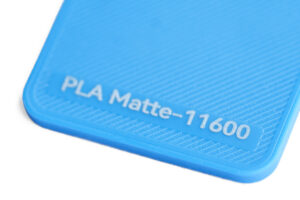 PLA Matte 11600 - KIT3D GmbH – 3D-Technologie & Konstruktion Close-up of a bright blue plastic surface with the embossed text 'PLA Matte-11600'.