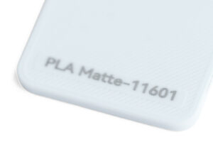 PLA Matte 11601 - KIT3D GmbH – 3D-Technologie & Konstruktion Close-up of a pale blue plastic corner with engraved text reading 'PLA Matte-11601'.