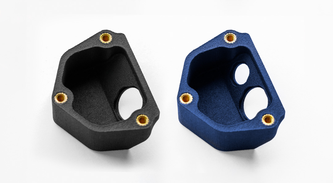 Zwei SLS-3D-Druckgehäuse in Schwarz und Royal Blue mit eingesetzten Gewindebuchsen, gefärbt mit DyeMansion