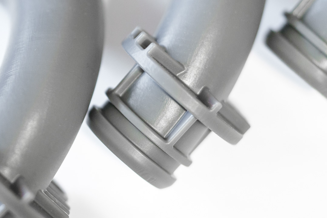 Graue SLA-3D-Druckbauteile mit glatter Oberfläche und präzise gefertigten Verbindungs- und Befestigungselementen