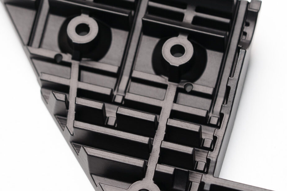 Chemisch geglättetes schwarzes 3D-Druck-Bauteil mit Rippen, Bohrungen und filigranen Funktionsdetails