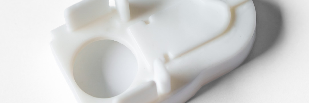 Weißes SLA-3D-Druckbauteil mit Bohrungen, Aufnahmen und glatter Oberfläche