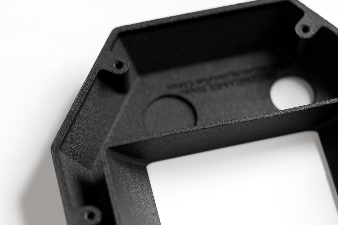 Schwarzes SLS-3D-Druckgehäuse mit integrierten Bohrungen, dünnen Wandstärken und fein strukturierter Oberfläche