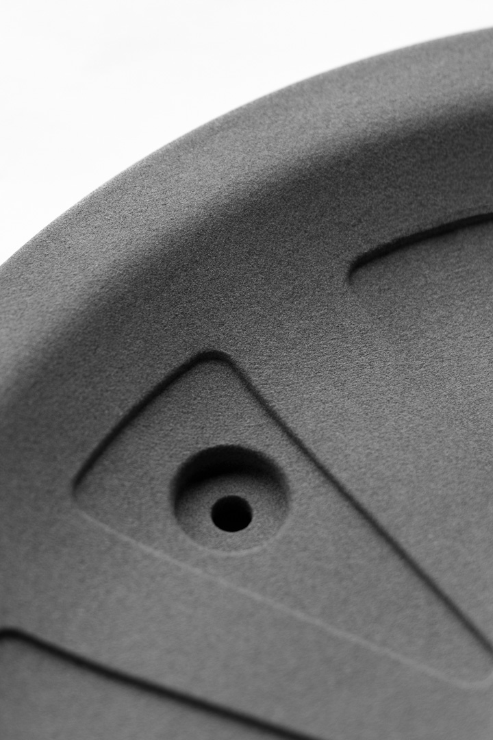 Nahaufnahme eines rohen grauen MJF-Bauteils mit typischer 3D-Druck-Oberfläche