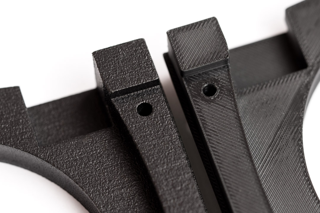 Vergleich eines schwarzen FDM-Bauteils aus ASA mit einem schwarz eingefärbten, verdichtungsgestrahlten MJF-Bauteil